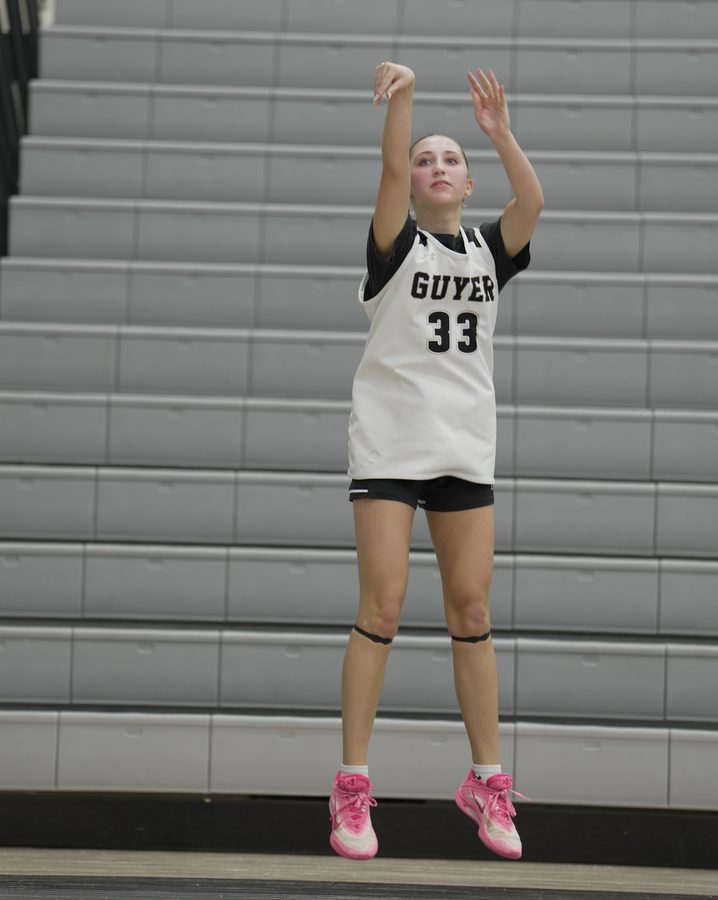 Addy holds her follow through after a jump shot in the gym.