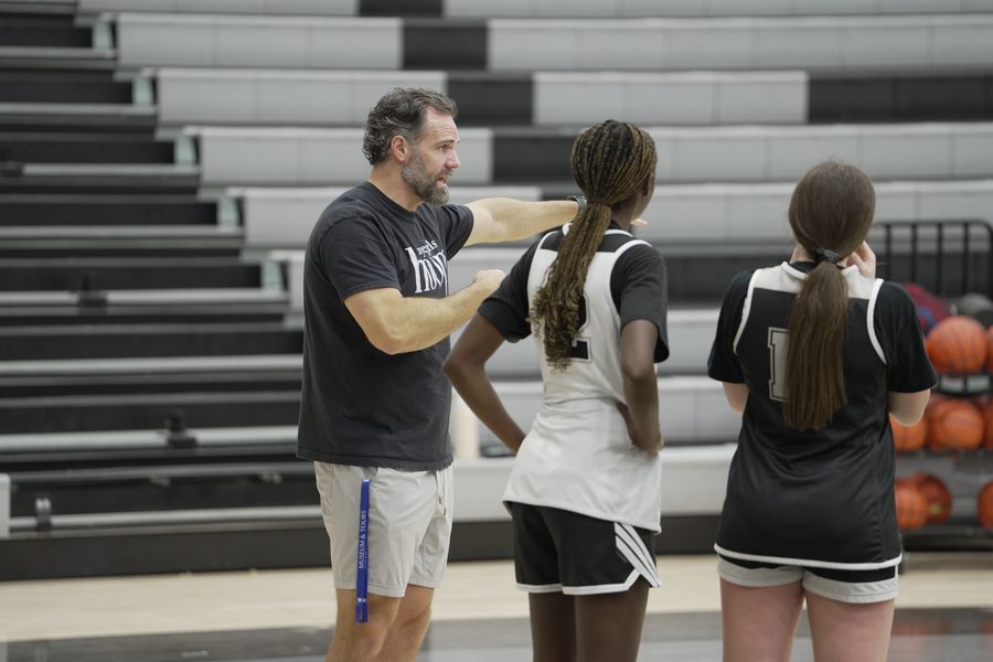 Coach Floyd walks Keziah and Emily through their spots on the floor.