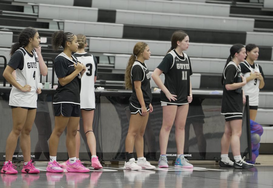 A line of Guyer players stands along the sideline waiting for their turn in September.